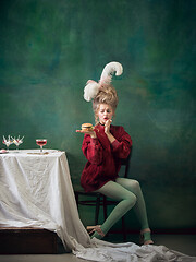 Image showing Young woman as Marie Antoinette on dark background. Retro style, comparison of eras concept.