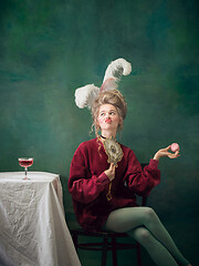 Image showing Young woman as Marie Antoinette on dark background. Retro style, comparison of eras concept.