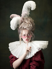 Image showing Young woman as Marie Antoinette on dark background. Retro style, comparison of eras concept.