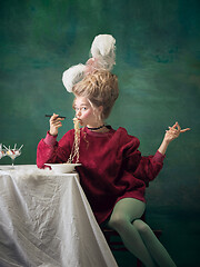 Image showing Young woman as Marie Antoinette on dark background. Retro style, comparison of eras concept.