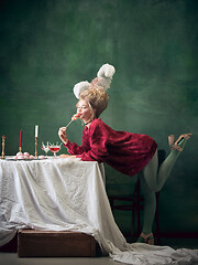 Image showing Young woman as Marie Antoinette on dark background. Retro style, comparison of eras concept.