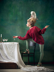 Image showing Young woman as Marie Antoinette on dark background. Retro style, comparison of eras concept.