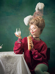 Image showing Young woman as Marie Antoinette on dark background. Retro style, comparison of eras concept.