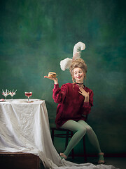 Image showing Young woman as Marie Antoinette on dark background. Retro style, comparison of eras concept.