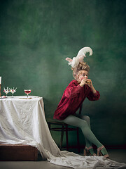 Image showing Young woman as Marie Antoinette on dark background. Retro style, comparison of eras concept.