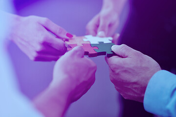 Image showing Group of business people assembling jigsaw puzzle