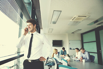 Image showing business man  on a meeting in offce with colleagues in backgroun