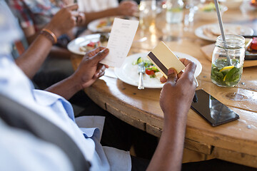 Image showing hands holding bill and credit card at restaurant