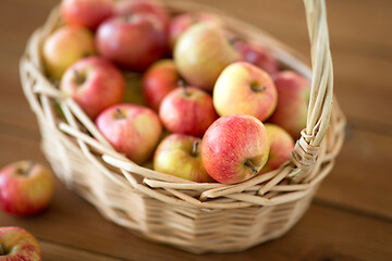 Image showing ripe apples in wicker basket on wooden table