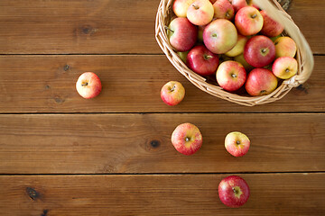 Image showing ripe apples in wicker basket on wooden table