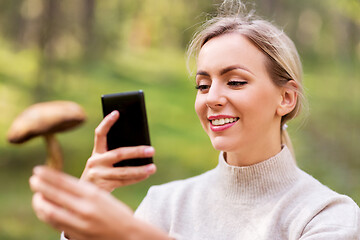 Image showing woman using smartphone to identify mushroom