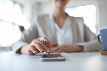 Image showing hand of businesswoman using smartphone at office