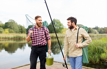 Image showing male friends with net and fishing rods on lake