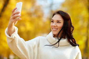 Image showing woman taking selfie by smartphone at autumn park