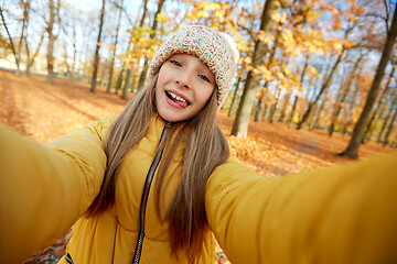 Image showing happy girl taking selfie at autumn park