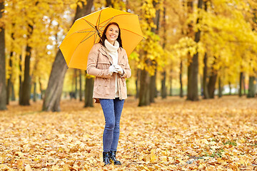 Image showing happy woman with umbrella in autumn park