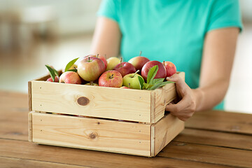 Image showing woman with wooden box of ripe apples