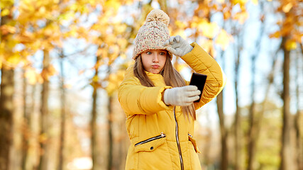 Image showing girl taking selfie by smartphone at autumn park