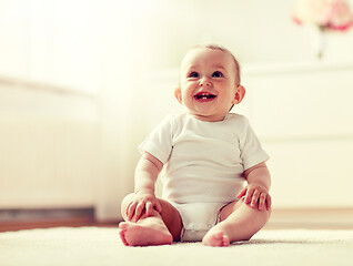 Image showing happy baby boy or girl sitting on floor at home