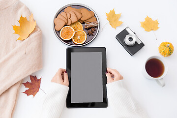 Image showing hands with tablet pc, tea and autumn leaves