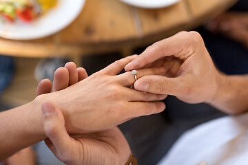 Image showing man giving diamond ring to woman at restaurant