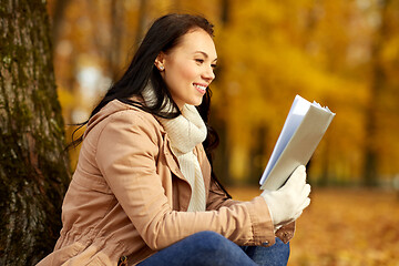 Image showing woman reading book at autumn park