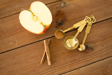 Image showing half apple and knife on wooden cutting board