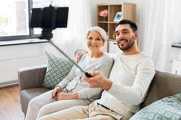 Image showing senior mother with adult son taking selfie at home