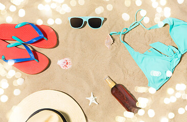 Image showing straw hat, flip flops and sunglasses on beach sand