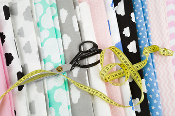 Image showing cotton fabric material, tailor measurement tape and scissors