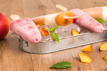 Image showing Homemade raspberries and peach popsicles