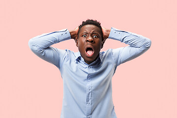 Image showing The young emotional angry man screaming on pink studio background