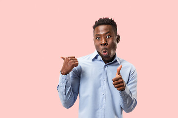 Image showing The happy businessman standing and smiling against pink background.