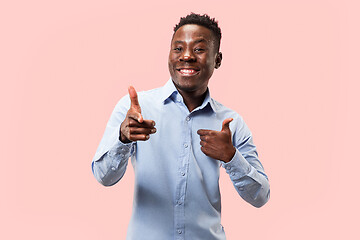 Image showing The happy businessman standing and smiling against pink background.