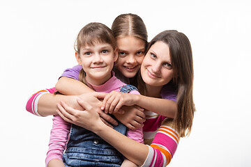 Image showing Two girls and a mother of European appearance happily look at the frame