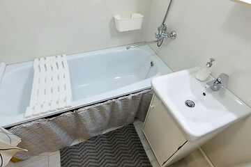 Image showing Small bathroom interior with bathtub and washbasin