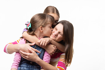 Image showing Two daughters kiss mom, isolated on white background