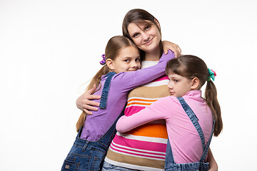 Image showing Children hug mom, mom looks happily in frame, isolated on white background