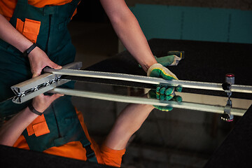 Image showing Worker cutting the surface of glass mirror