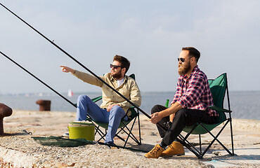 Image showing male friends with fishing rods on pier