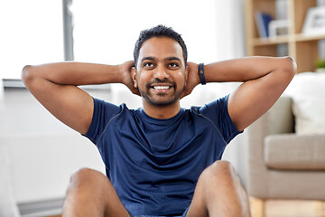 Image showing indian man making abdominal exercises at home