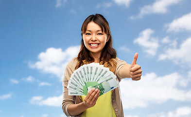 Image showing asian woman with euro money showing thumbs up