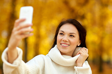 Image showing woman taking selfie by smartphone at autumn park