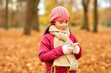 Image showing girl with smartphone at autumn park