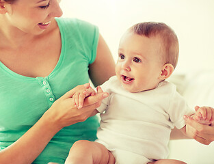 Image showing happy young mother with little baby at home