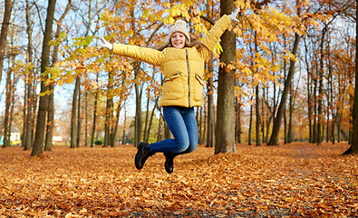 Image showing happy girl jumping at autumn park