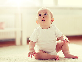 Image showing happy baby boy or girl sitting on floor at home