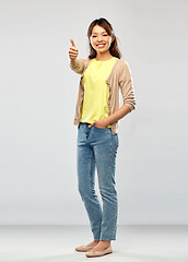 Image showing happy asian woman showing thumbs up over grey