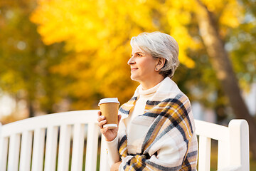 Image showing senior woman drinking coffee in autumn park