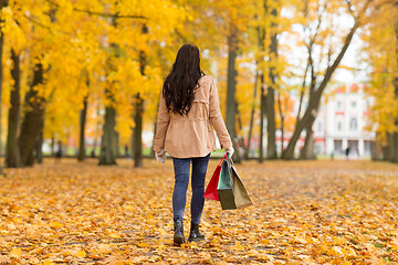 Image showing woman with shopping bags walking along autumn park